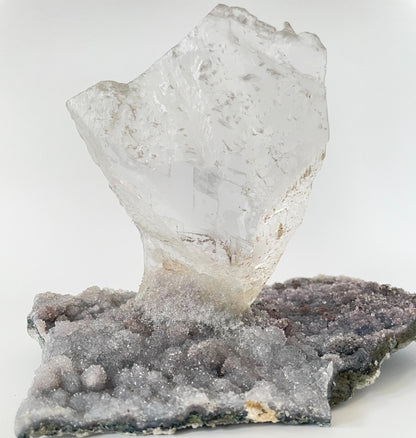 Large slab of amethyst with micro-crystallization with a large formation of gypsum protruding perpendicular from the slab.