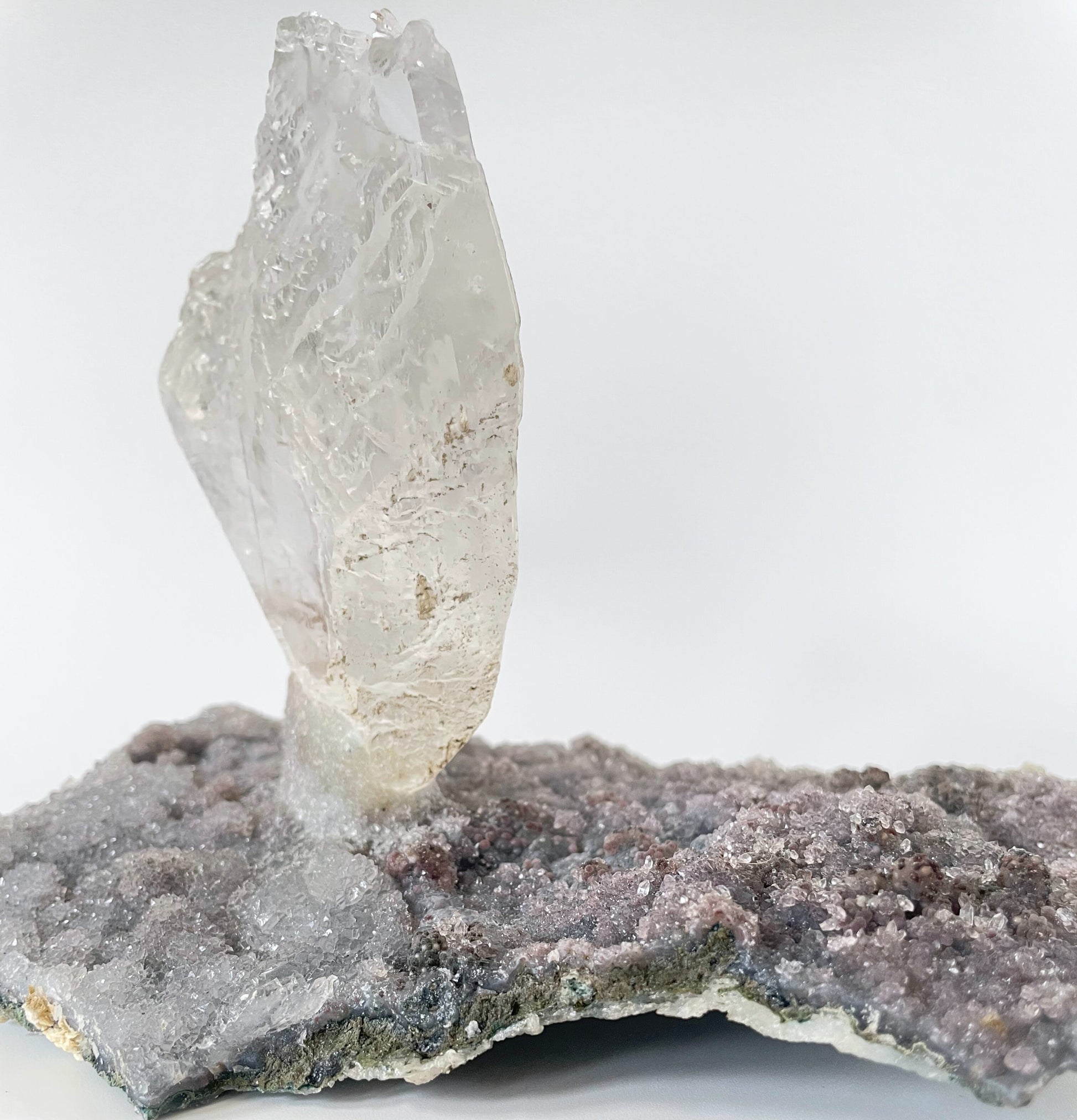 Large slab of amethyst with micro-crystallization with a large formation of gypsum protruding perpendicular from the slab.