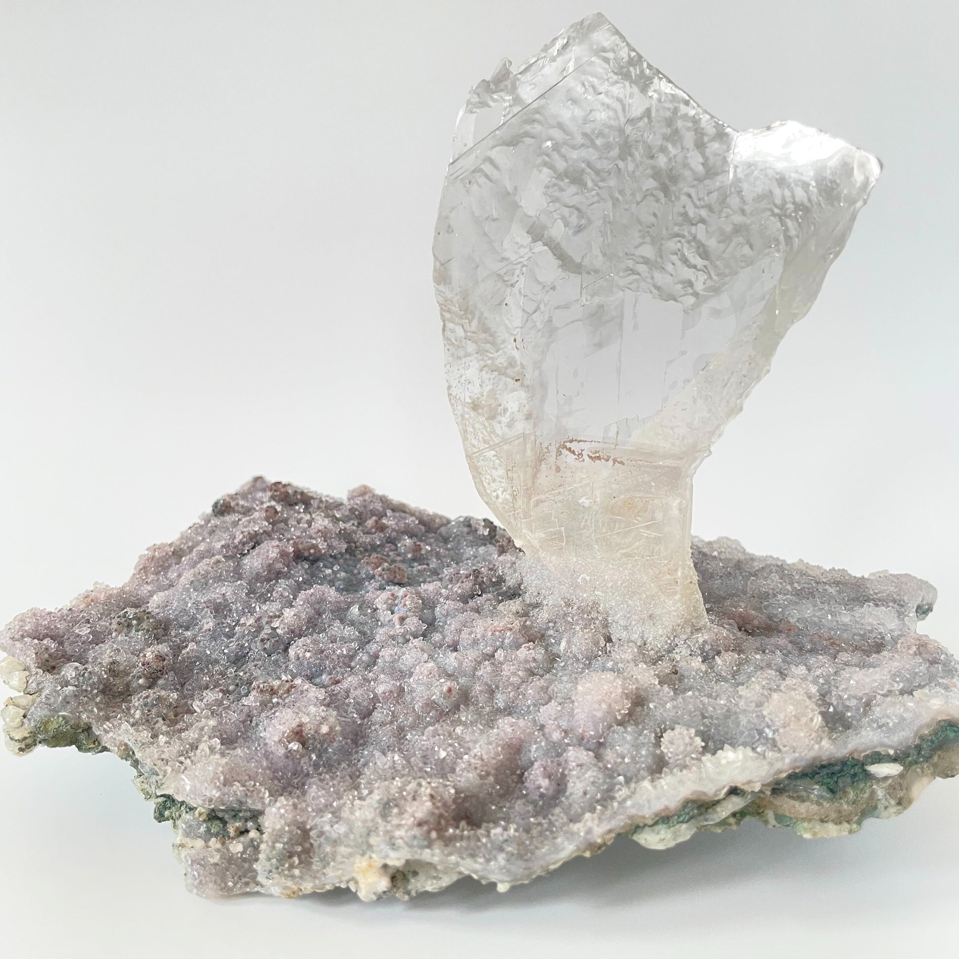 Large slab of amethyst with micro-crystallization with a large formation of gypsum protruding perpendicular from the slab.