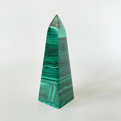 A 3.9-inch malachite obelisk with vibrant green hues and intricate patterns on a white background.