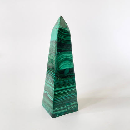 A 3.9-inch malachite obelisk with vibrant green hues and intricate patterns on a white background.