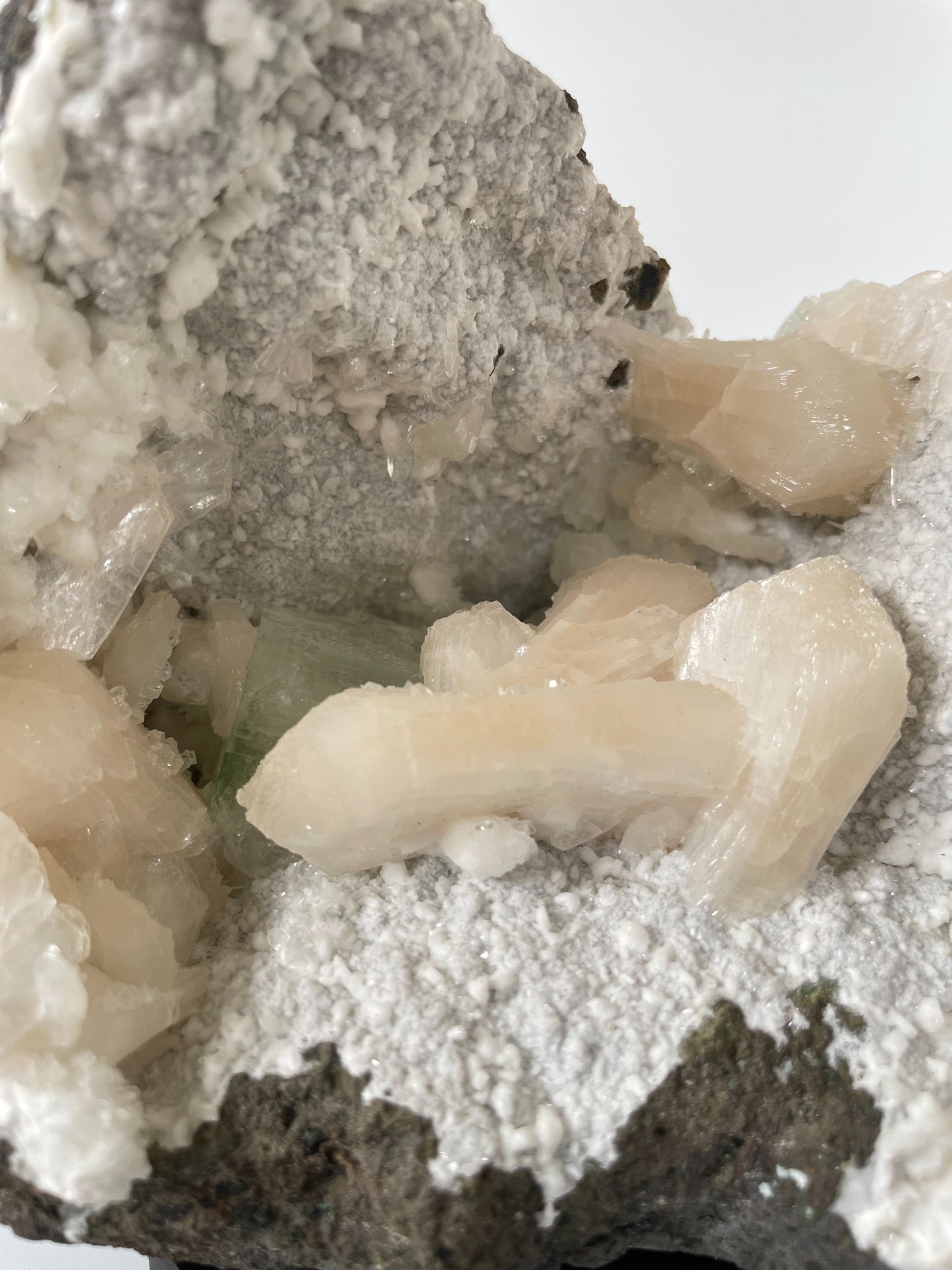 A close-up of a large Heulandite cluster with well-defined peach Stilbite and green Apophyllite crystals.