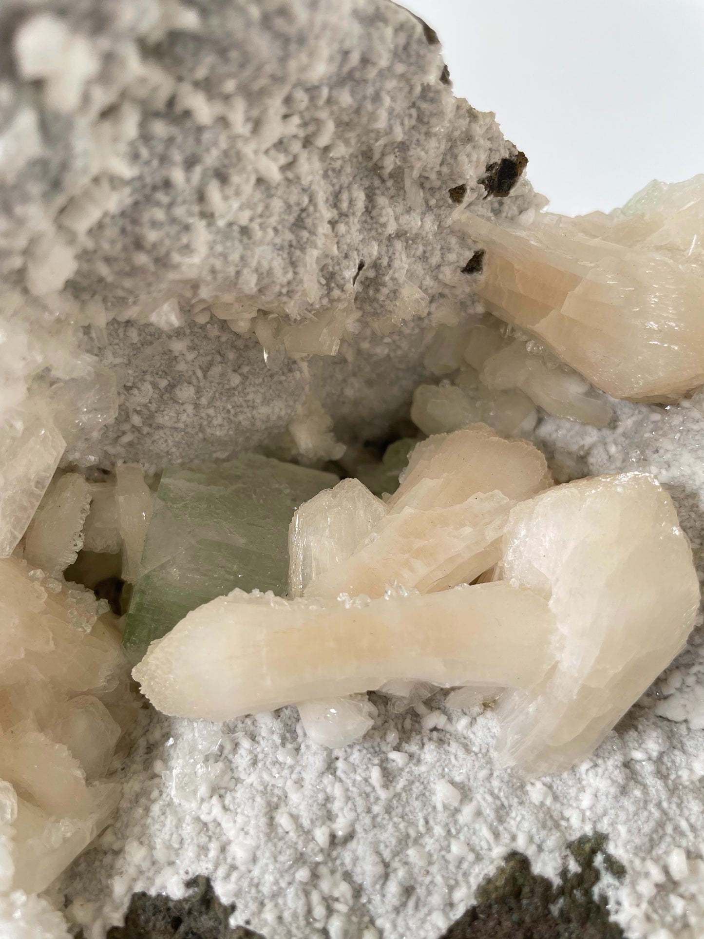 A close-up of a large Heulandite cluster with well-defined peach Stilbite and green Apophyllite crystals.