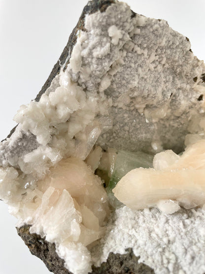 A close-up of a large Heulandite cluster with well-defined peach Stilbite and green Apophyllite crystals.