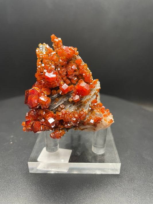 Close-up photo of stunningly large Vanadinite crystals perched on a Barite matrix, weighing 120.4 grams. The fiery red-orange Vanadinite crystals contrast beautifully against the soft white Barite, creating a mesmerizing display of natural beauty.