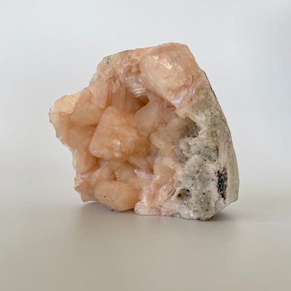 A 3-inch stilbite cluster with distinctive peach-colored crystal formations on a white background.