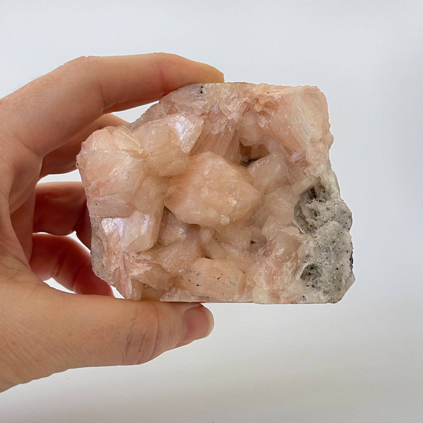 A 3-inch stilbite cluster with distinctive peach-colored crystal formations on a white background.