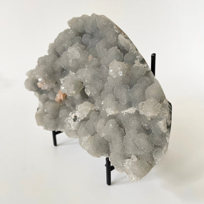 A rare 4.5-inch blue chalcedony cluster with soft blue hues on a white background. It has accents of stilbite and apophyllite crystal formations.