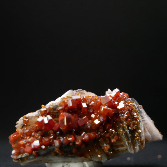 Vanadinite specimen on matrix from Morocco, weighing 28.2 grams. The specimen showcases vibrant red-orange crystals on a natural rock matrix, offering a glimpse into the beauty of mineral treasures.